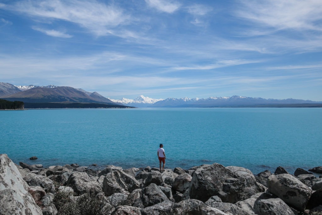 A man standing by a lake in new zealand
