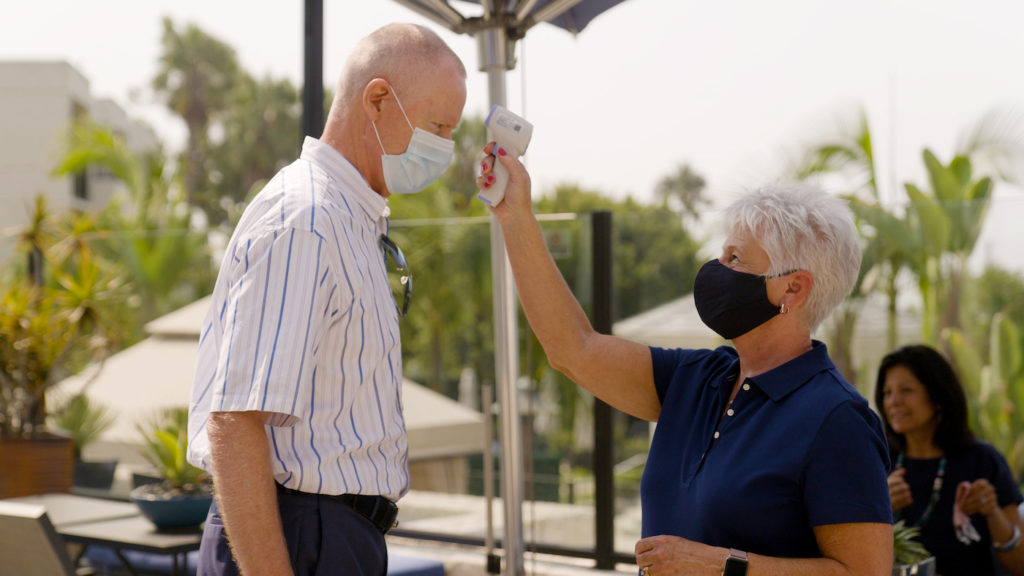 A Trafalgar wellbeing director checking a guest's temperature