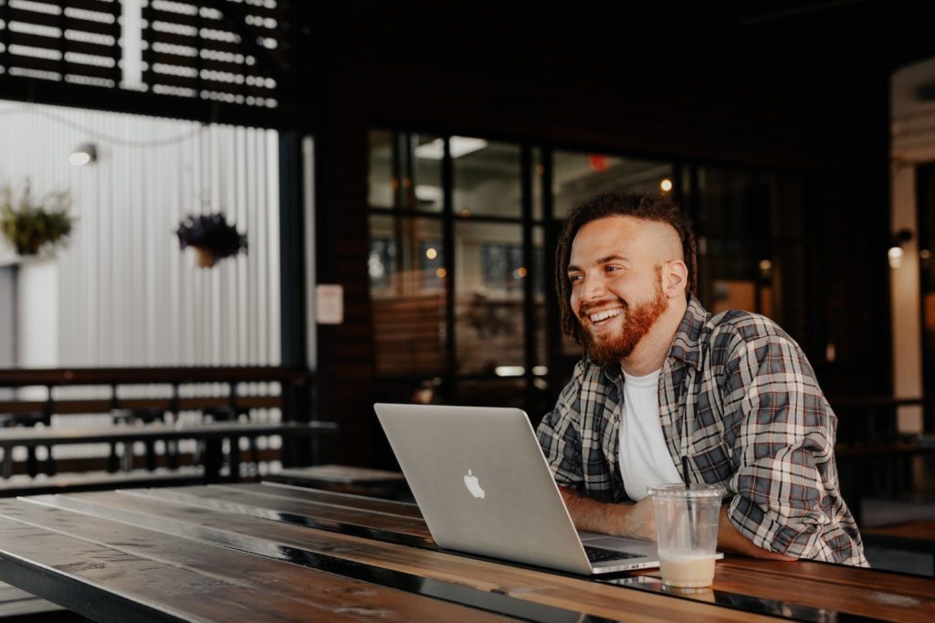 a man with a laptop drinking a coffee